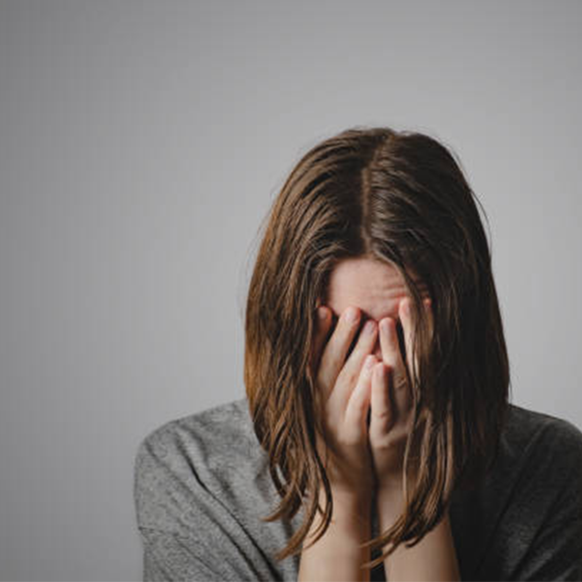 Woman with head in hands trying to cope